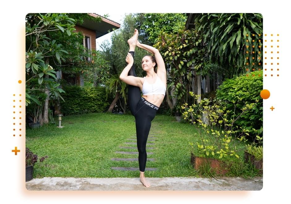 Hanna Pliasetski performing an advanced standing split in a garden setting.